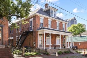 a red brick house with a staircase in front of it at Housepitality - Cityscape - Historic 2BR in Columbus