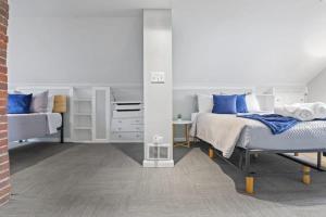 1 dormitorio con 2 camas y almohadas azules en Housepitality - Newark Friends and Family House, en Newark