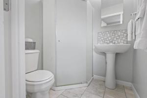 La salle de bains blanche est pourvue de toilettes et d'un lavabo. dans l'établissement Housepitality - Newark Friends and Family House, à Newark