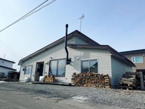 een huis met een stapel hout ervoor bij yadorigi（ヤドリギ） in Ikeda