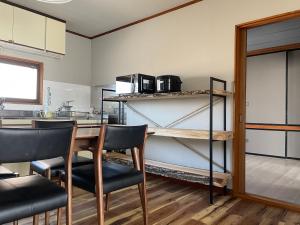 uma cozinha com mesa e cadeiras num quarto em yadorigi（ヤドリギ） em Ikeda
