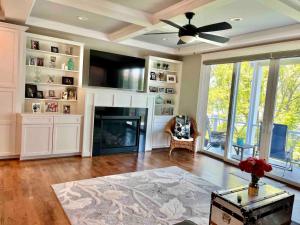 a living room with a fireplace and a ceiling fan at The Fritz! - South River Waterfront With Elevator in Edgewater