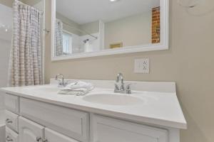 a white bathroom with a sink and a mirror at Housepitality - Harrison Mansion - Great Location in Columbus