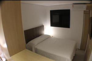 a small bedroom with a bed and a flat screen tv at Fabio Av Paulista in São Paulo +6 photos