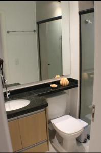 a bathroom with a toilet and a sink and a mirror at Fabio Av Paulista in São Paulo