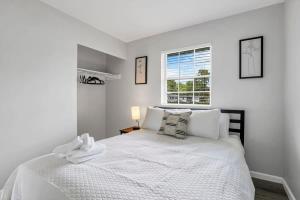 a white bedroom with a large bed with a window at Housepitality - The Gahanna Ranch - 3 BR - Airport in Gahanna