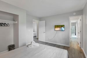 a white bedroom with a bed and a painting on the wall at Housepitality - The Gahanna Ranch - 3 BR - Airport in Gahanna