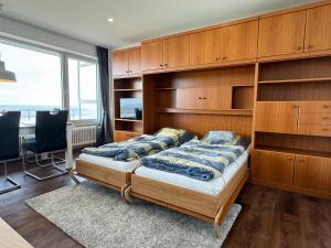 a bedroom with a bed and a desk and a window at Haus Monopol "Himmel und Meer" - direkter Meerblick mit Nord-Balkon in Wangerooge