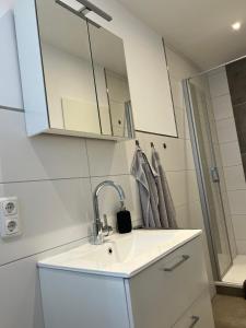a bathroom with a sink and a mirror at Haus Monopol "Himmel und Meer" - direkter Meerblick mit Nord-Balkon in Wangerooge +20 photos