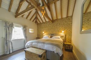 斯坦福德的住宿－Pea Cottage，一间卧室设有一张大床和砖墙