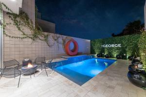a swimming pool with chairs and a fire in front of a building at The George - Old Town Scottsdale private micro-resort, near the best restaurants and nightlife in AZ in Scottsdale