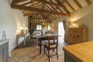 a kitchen and living room with a table and a desk at Pea Cottage in Stamford