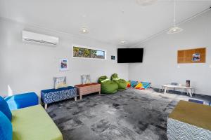 Tasman Holiday Parks - Rotorua في روتوروا: غرفة معيشة مع كراسي وتلفزيون بشاشة مسطحة