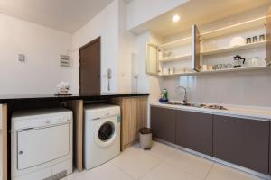 a kitchen with a washing machine and a washer at Luxury 3 bedroom at Regalia Kuala Lumpur in Kuala Lumpur