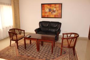 a living room with a couch and a table and a chair at Hotel Residence Flamani in Lomé