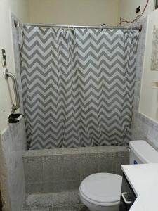 uma casa de banho com um WC e uma cortina de chuveiro em Casa completa en Xela em Quetzaltenango
