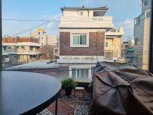 einen Balkon mit einem Tisch und einem Gebäude in der Unterkunft hongdae Gangnam line 2 st 1 min in Seoul