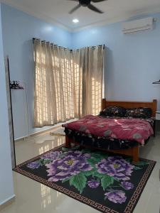 - une chambre avec un lit et un tapis au sol dans l'établissement Zayyans Homestay, à Kampong Merabang Likar