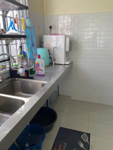 - une cuisine avec un évier et un comptoir dans l'établissement Zayyans Homestay, à Kampong Merabang Likar