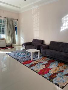 - un salon avec un canapé et une table sur un tapis dans l'établissement Zayyans Homestay, à Kampong Merabang Likar