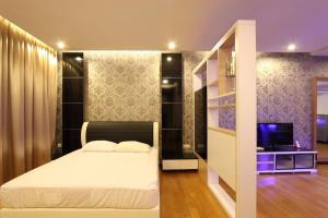 a bedroom with a bed and a staircase and a television at Kuala Lumpur Regalia Deluxe Suite in Kuala Lumpur