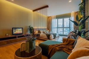 a living room with a couch and a tv at KLCC View Savannah- In a Tropical State of Mind in Kuala Lumpur