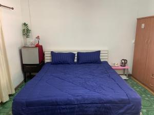 a bed in a bedroom with a blue comforter at Welcome to Hang Dong - close to the Night Safari in Chiang Mai