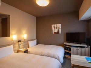 Postel nebo postele na pokoji v ubytování Hotel Route Inn Miyoshi Ekimae