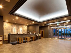 a lobby with a restaurant with a counter and stools at Hotel Route Inn Miyoshi Ekimae in Miyoshi