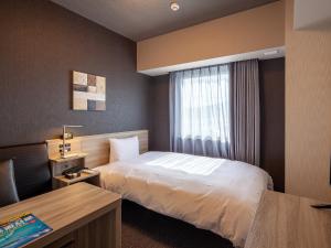 Postel nebo postele na pokoji v ubytování Hotel Route Inn Miyoshi Ekimae