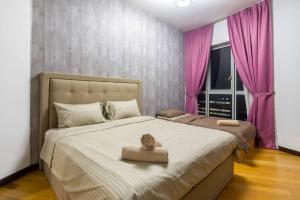 a bedroom with a large bed with pink curtains at Spacious 3 Bedroom with KLCC View in Kuala Lumpur
