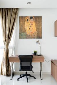 un escritorio con una silla y un cuadro en la pared en Float in the Infinity Pool of a Gorgeous Apartment, en Kuala Lumpur