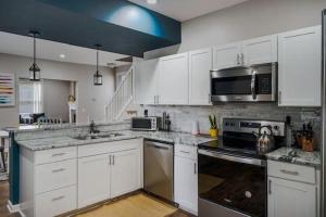 コロンバスにあるHousepitality - The Lilley Pad - Near Downtownの白いキャビネットとステンレス製の電化製品を備えたキッチン