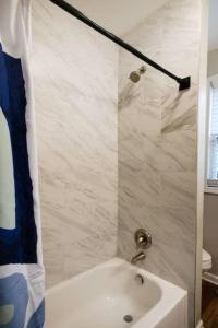a bathroom with a sink and a shower curtain at Housepitality - The Lilley Pad - Near Downtown in Columbus
