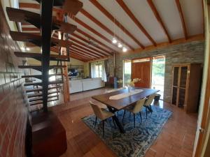 cocina y comedor con mesa de madera y sillas en Casona en Valle Los Coligues, en Quilpué