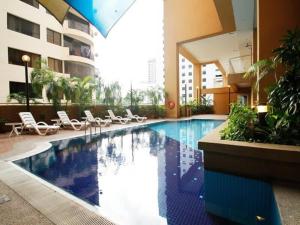 a large swimming pool in a building with lounge chairs at Lavish Loft 12 Steps Away From Bukit Bintang in Kuala Lumpur