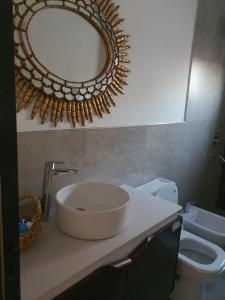 La salle de bains est pourvue d'un lavabo et d'un miroir sur un comptoir. dans l'établissement Casa en Santa Ana Corrientes capital, à Corrientes