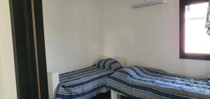 2 camas individuais num pequeno quarto com uma janela. em Casa en Santa Ana Corrientes capital em Corrientes