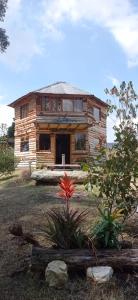 a log house with a garden in front of it at Eco-cabaña piemonte in Guasca