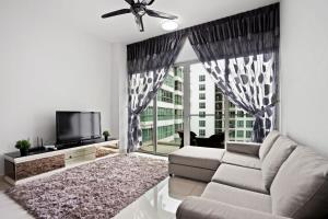 een woonkamer met een bank en een tv bij Simplicity Retreat Cozy 2BR with Infinity Pool in Kuala Lumpur