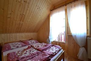 a bedroom with two beds and a window at Domki ogrzewane Sokół in Władysławowo