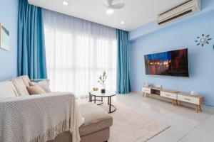 - un salon bleu avec un canapé et une télévision dans l'établissement 1BR Peace of Mind Mediterranean Style Condo, à Kuala Lumpur