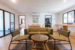 Dolphin Bay Beach Resort في سام رويْ يوت: غرفة معيشة مع أريكة وكراسي وطاولة