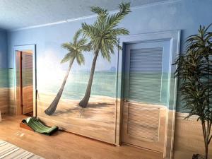 a mural of a beach with palm trees on a wall at Beautiful One of Kind Place in downtown Sandusky! in Sandusky