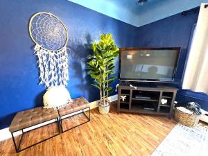 a living room with a tv and a blue wall at Beautiful One of Kind Place in downtown Sandusky! in Sandusky