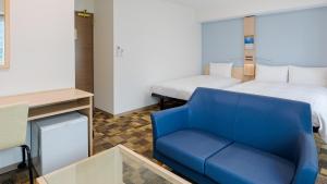 大阪市にある東横INN大阪なんばの青い椅子とベッドが備わる客室です。