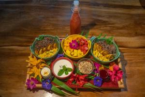 uma bandeja com tigelas de comida e flores numa mesa em El Sol Monteverde em Monteverde