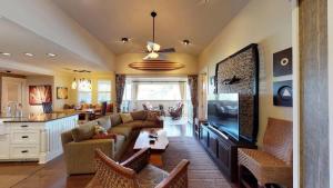 a living room with a couch and a flat screen tv at C300 Custom 4 bedroom Ocean View Penthouse in Koloa
