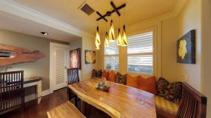 a dining room with a wooden table and a couch at C300 Custom 4 bedroom Ocean View Penthouse in Koloa +39 photos