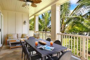 a porch with a table and chairs and a couch at D211 Second Floor 3-bedroom Poolside Lanai in Koloa